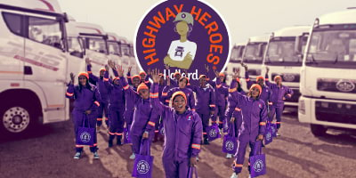 Hollard Highway Heroes Women In Transport group in purple overalls by trucks